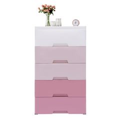 a pink and white dresser with flowers on top