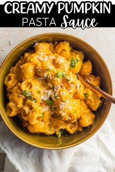 creamy pumpkin pasta sauce in a yellow bowl with a wooden spoon and white napkin on the side