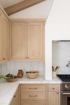 a kitchen with wooden cabinets and white marble counter tops, an oven and dishwasher