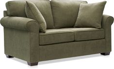 a green couch with two pillows on it