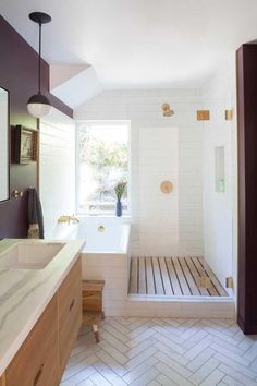 a bathroom with a tub, sink and shower in it's own area that is well lit by the window