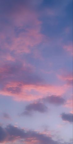 an airplane is flying in the sky with pink and blue clouds behind it at sunset