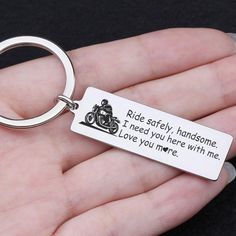 a hand holding a metal keychain that says the best kind of girlfriend is loved by a hunter