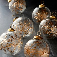 six glass ornaments with gold leaf designs on them