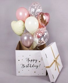 a birthday card and balloons in a box