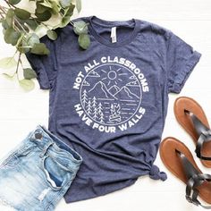 a t - shirt with the words not all classrooms have four walls on it next to sandals