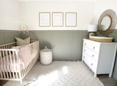 a baby's room with a crib, dresser and pictures on the wall