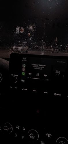 the dashboard of a car with rain on it