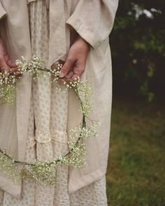 a woman holding a wreath with baby's breath