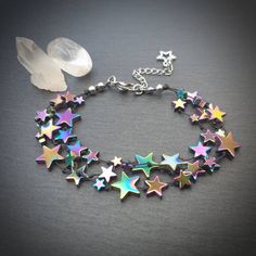 "This bracelet is made from rainbow coloured, star shaped hematite beads on waxed thread, with stainless steel findings and a tibetan silver charm  The bracelet comes in 2 sizes -  ⭐Small - Medium  Bracelet length 6.5 inches, plus 1.5 inch extender chain.  This will fit a wrist with a circumference of approximately 6 - 7 inches  ⭐Medium - Large Bracelet length 7.5 inches, plus 1.5 inch extender chain.  This will fit a wrist with a circumference of approximately  7 - 8 inches. As well as being a beautifully unique stone hematite is said to have a highly protective energy and is good for helping women who lack courage\". Disclaimer - we do not guarantee that this bracelet will make you brave 😉 Black hematite bracelet   https://www.etsy.com/uk/listing/800387014/star-shaped-hematite-bracelet- Rainbow Star-shaped Jewelry With Star Charm, Handmade Multicolor Star Bracelets, Rainbow Star-shaped Bracelet For Gift, Handmade Rainbow Star Jewelry, Multicolor Star Charm Bracelet, God Jewelry, Nerd Aesthetic, Rainbow Hematite, Character Clothes