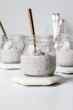 three mason jars filled with oatmeal sitting on top of a white counter