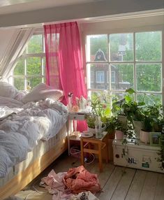 a bed room with two beds covered in white blankets and pink drapes next to a window