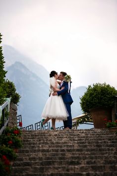 a bride and groom kissing on the steps