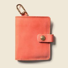 an orange leather wallet with a metal keychain hanging from it's side