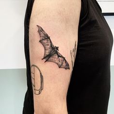 a bat tattoo on the left upper arm