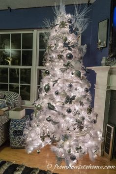 a white christmas tree with lights and ornaments