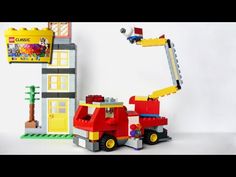 a toy firetruck with a ladder attached to it and a building in the background