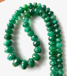 two strands of green beads on a white surface