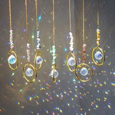 the sun shines brightly through several different necklaces hanging from chains on a wall