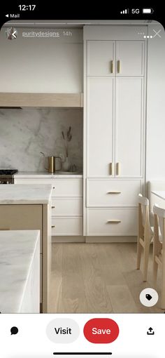 a kitchen with white cabinets and marble counter tops