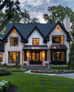 a large white house with lots of windows and lights on it's front porch