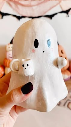 a person holding up a fake ghost with two small bears on it's face