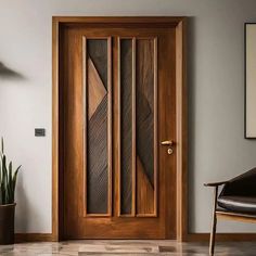 a wooden door in a room with a chair and potted plant next to it