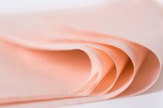 several sheets of pink colored paper on a white surface