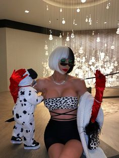 a woman sitting on top of a wooden floor next to a dalmatian dog