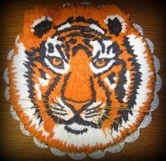 an orange and black tiger head on top of a doily