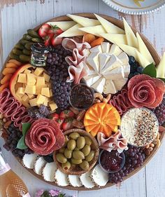 a platter filled with different types of cheeses and meats