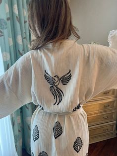 "Beautiful handmade long white Phoenix bird celestial print kimono robe, designed with cotton fabric, it flows as you move for a comfortable wear. Beach cover up, a kimono with Phoenix bird.  This is a lovely, good-quality kimono, with traditional breathable kimono sleeves.        A belt that ties around the waist. Great to wear around the house, on beaches, or to dress up with some jeans & a T-shirt, covering up on the beach with a swimsuit.         We love kimonos as they are so versatile. They also make really special & unique birthday, valentines Day, Christmas gifts, and Mother's Day gifts. The perfect combination of comfort and style, this kimono is a great addition to your new season wardrobe.    Cotton Fabric and Handmade      Length from shoulder: 75 CM Width: 130 CM Kimono Size: Celestial Print, Phoenix Bird, Unique Birthday, Kimono Sleeves, Boho Kimono, Print Kimonos, Pajama Robe, Kimono Cardigan, Womens Robes