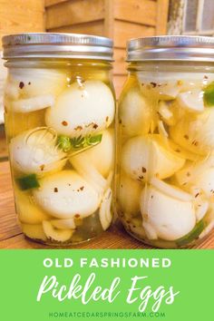 two jars filled with pickled eggs on top of a wooden table