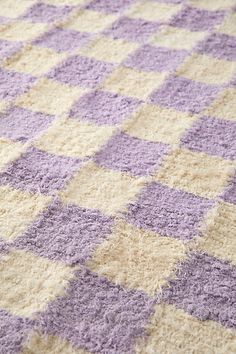 a purple and white checkered rug on the floor