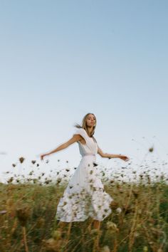 a woman in a field with her arms outstretched