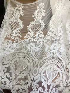 "This stunning Lace Fabric design piece has soft hand feel, It's perfect for weddings, bridal parties, and any events. Shop our large inventory of bridal fabrics. ☆PRODUCT DESCRIPTION : This gorgeous fabric is made on a sheer base with a beautiful vintage star embroidery throughout. The fabric width is approximately 51\" (130cm) Wide. Color: off-white as in picture Material: Rayon, Polyester ☆ PURCHASING INFORMATION: This fabric is sold by the yard and each Qty you enter will represent 1 yard of Embroidered Lace Wedding Dress For Mother Of The Bride, Embroidered Lace Wedding Dress For Ceremony, Elegant White Embroidered Veil, Embroidered Lace Tulle Fabric For Wedding, Intricate Lace Embroidery Fabric For Brides, White Tulle Fabric With Intricate Embroidery For Ceremony, Embroidered Tulle Lace For Wedding, Wedding Lace With Embroidered Tulle, Prom Dress Fabric