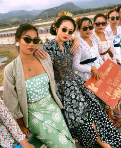 several women are posing for the camera with their arms around each other while wearing sun glasses