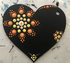 a black heart with orange and yellow decorations on it