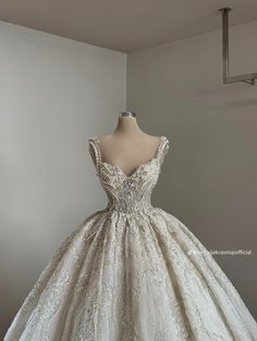 a white wedding dress is on display in front of a mannequin's head