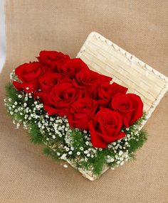 red roses in a basket with baby's breath