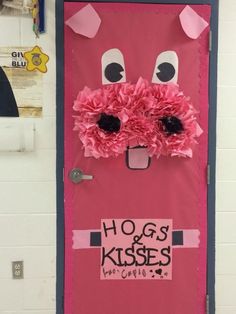 a door decorated with pink tissue paper flowers and the words hogs & kisses on it