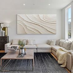 a living room filled with furniture and a large painting on the wall above the couch