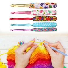 a woman is knitting with crochet needles in front of several different colors of yarn