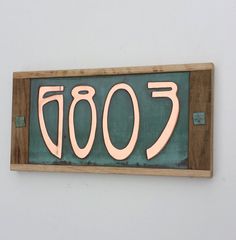 a wooden sign with the number 700 written in pink on it's bottom half