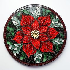 a red poinsettia on a stained glass plate