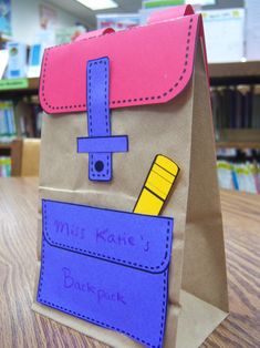 a brown paper bag with a purple and yellow design on it sitting on top of a wooden table