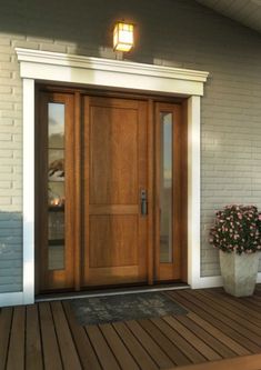 a wooden door with two planters on the front porch