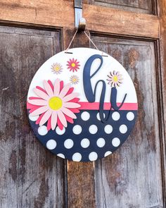 a door hanger that has the letter j on it with flowers and polka dots