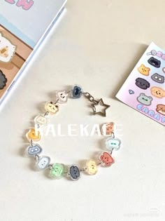 a bracelet with various buttons on it next to a card and sticker book that says kalekae