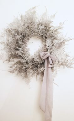 a dried wreath with a light gray ribbon